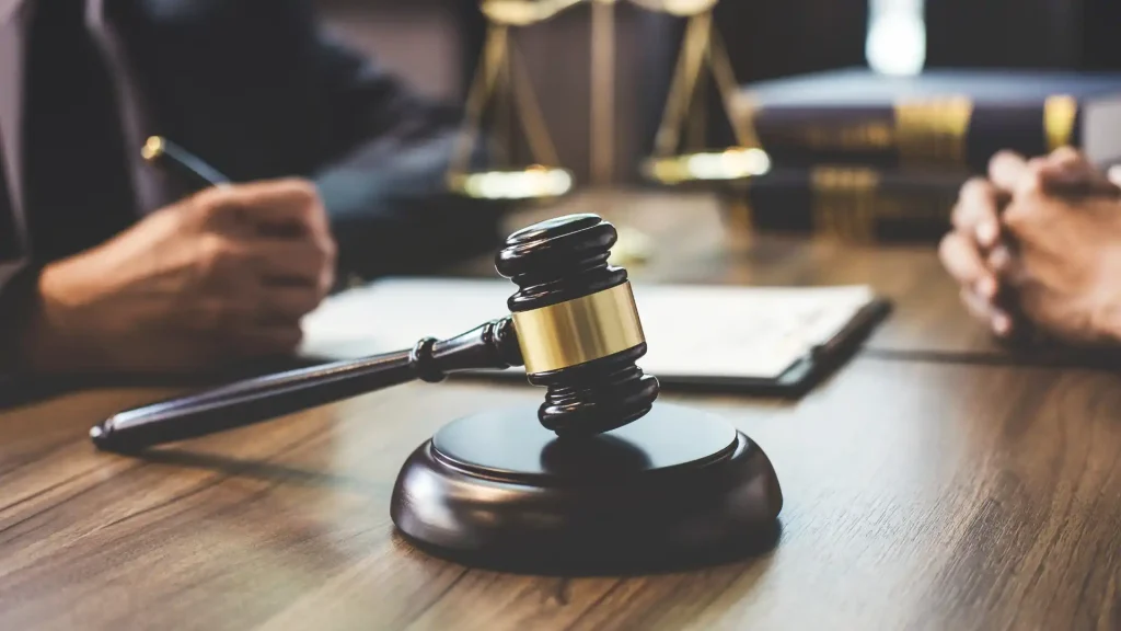 Gavel on block with legal documents in the background.
